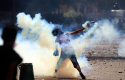 An Egyptian protester throws a tear gas canister toward riot police during clashes near the U.S. Embassy in Cairo, Egypt, Sept. 13, 2012. (AP)