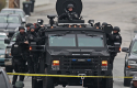Police in tactical gear arrive on an armored police vehicle search for Dzhokhar Tsarnaev / AP
