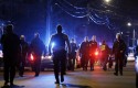 Police officers walk near a crime scene in Watertown, Mass. on April 19 / AP