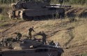 Israeli soldiers work on top of a tank in a position in the Israeli controlled Golan Heights / AP