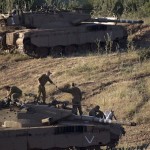 Israeli soldiers work on top of a tank in a position in the Israeli controlled Golan Heights / AP