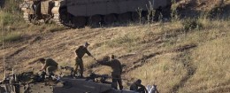Israeli soldiers work on top of a tank in a position in the Israeli controlled Golan Heights / AP