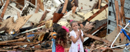 Two girls stand in rubble after a tornado struck Moore, Okla. REUTERS/Gene Blevins