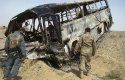 Burned bus after it collided with the wreckage of a truck that was attacked by Taliban insurgents in Afghanistan / AP