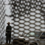 A U.S. Border Patrol agent is seen from Mexico through the fence along the US-Mexico border / AP