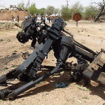 Twisted metal lies at the site of a morning car bomb attack inside a military camp in Agadez, in northern Niger, Thursday, May 23, 2013. (AP)