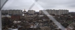 Smoke rises from a destroyed house, in foreground center, damaged in Saturday's shelling at Vostochniy district of Mariupol, Ukraine, Monday, Jan. 26, 2015