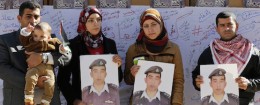 Relatives of Islamic State captive Jordanian pilot Muath al-Kasaesbeh hold pictures of him as they join students during a rally calling for his release, at Jordan University in Amman February 3