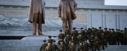 North Korean soldiers walk past statues of deceased leaders Kim Il-Sung and Kim Jong-Il / AP