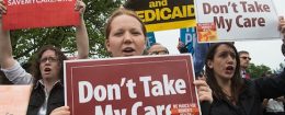 Protesters hold signs and shout at lawmakers walking out of the US Capitol after the House of Representatives narrowly passed a Republican effort to repeal and replace Obamacare