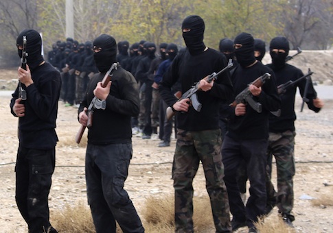 Islamist fighters walk with their weapons during their graduation ceremony at a camp in eastern al-Ghouta, near Damascus