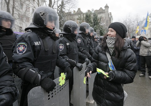 An activist decorates the shields of riot police