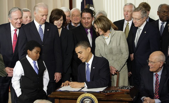 President Barack Obama signs the health care bill in the East Room of the White House