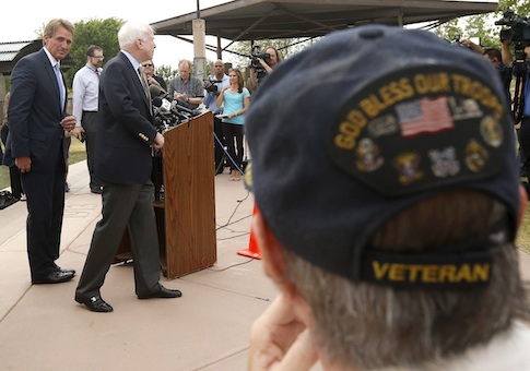 With Vietnam military veteran Chuck Tharp, right, listening in, Sen. John McCain, second from left, R-AZ, and Sen. Jeff Flake, left, R-AZ, finish up a news conference to discuss recent reports that dozens of VA hospital patients in Arizona may have died while awaiting medical care in the Phoenix VA Health Care System