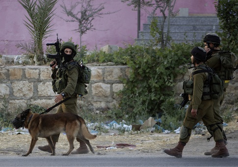 Israeli soldiers walk during an operation in search of kidnapped teenagers