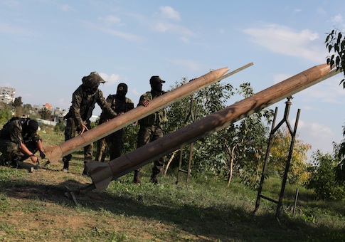 Masked Palestinian militants from Islamic Jihad place homemade rockets during a training exercise on the outskirts of Gaza City