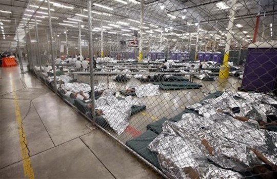 Detainees sleep and watch television in a holding cell where hundreds of mostly Central American immigrant children are being processed and held at the U.S. Customs and Border Protection Nogales Placement Center