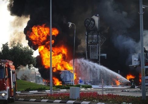 An Israeli firefighter tries to extinguish a petrol station on fire after it was hit by a rocket fired from Gaza in Ashdod, Israel, Friday, July 11
