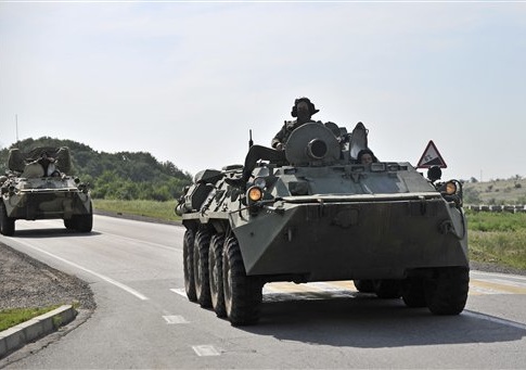 Two Russian armored personal carriers roll near the border with Ukraine outside the Russian town of Donetsk