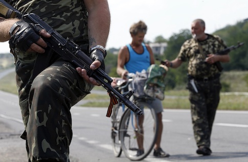 Armed pro-Russian separatists stand guard at a checkpoint in the settlement of Yasynuvata outside Donetsk