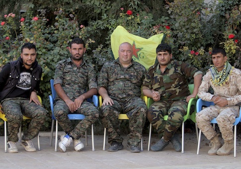 Brian Wilson (C), who said he is a U.S. citizen and a former soldier from Ohio, and who has joined the Kurdish People's Protection Units (YPG), sits with YPG members during an interview with Reuters in the northeast Syrian Kurdish city of Qamishli October 6, 2014