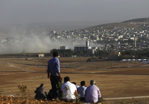 Turkish Kurds look towards the Syrian Kurdish town of Kobani from the top of a hill close to the border line between Turkey and Syria near Mursitpinar