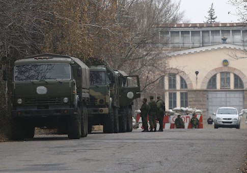 Armed people and military trucks are seen near a checkpoint outside a building in the territory controlled by the self-proclaimed Donetsk People's Republic in Donetsk, eastern Ukraine, November 12