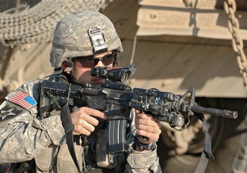 An infantryman of the 3rd US Stryker Brigade Combat Team aims with this M4A1 carbine during a search operation in Bagdad, Iraq, March 2007