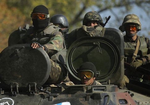 Ukrainian servicemen ride on an armoured vehicle near the eastern Ukrainian town of Debaltseve October 6, 2014