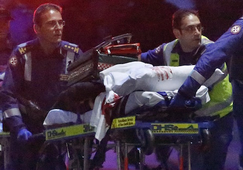 Paramedics remove a person, with bloodstains on the blankets covering the person, on a stretcher from the Lindt cafe, where hostages were being held, at Martin Place in central Sydney December 16