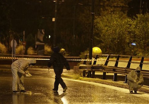 Police forensic experts investigate an area near Israeli Embassy in Athens