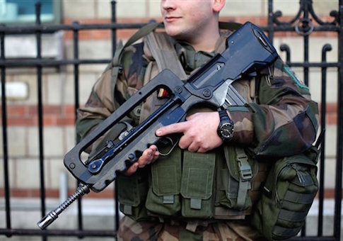 A French soldier helps secure the perimeter of a Jewish school in Paris as part of the highest level of security plan after last week's attacks by Islamist militants, Wednesday, Jan. 14