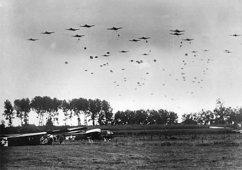 American paratroopers drop from a fleet of carrier planes to land near Grave in the Netherlands in 1944 during World War II. In the foreground, left, are gliders which have already landed with airborne troops.