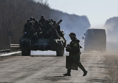 Ukrainian servicemen ride on a tank as they leave an area around Debaltseve, eastern Ukraine near Artemivsk, February 18, 2015