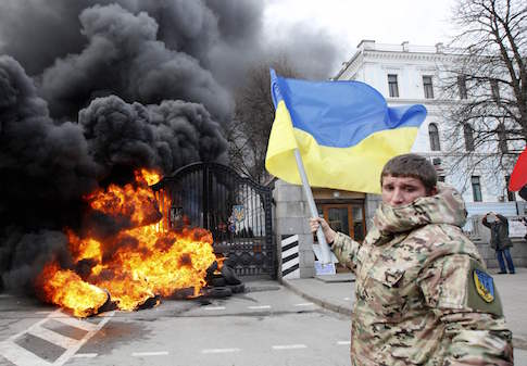 A serviceman from the battalion "Aydar" waves a Ukrainian flag during a protest against the disbanding of the battalion, in front of Ukraine's Defence Ministry in Kiev February 2 / Reuters