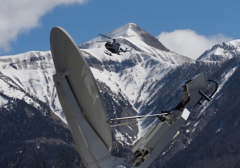 A rescue helicopter from the French Gendarmerie lands behind a media satellite dish seen during operations near the crash site of an Airbus A320, in Seyne-les-Alpes