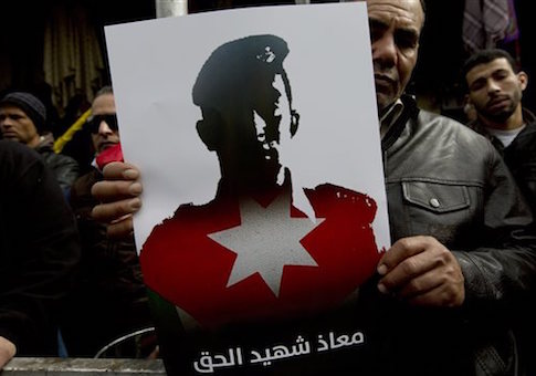 A Jordanian demonstrator carries a poster with a picture of slain Jordanian pilot, Lt. Muath al-Kaseasbeh