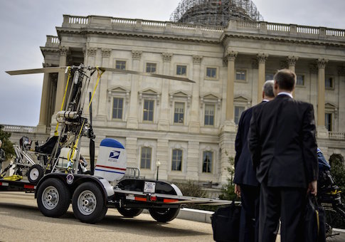 People watch as a gyro copter that was flown onto the grounds of the U.S. Capitol is towed from the west front lawn in Washington