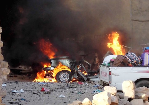 A car is engulfed by flames during clashes in the city of Ramadi