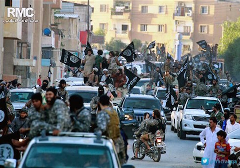 In this undated file image posted on Monday, June 30, 2014, by the Raqqa Media Center of the Islamic State group, a Syrian opposition group, which has been verified and is consistent with other AP reporting, fighters from the Islamic State group parade in Raqqa, north Syria