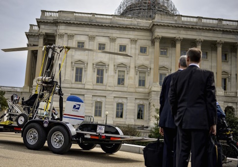 People watch as a gyro copter that was flown onto the grounds of the U.S. Capitol is towed from the west front lawn in Washington