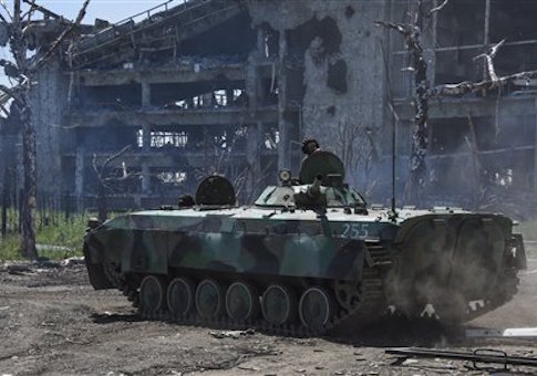A Russia-backed armoured personnel carrier makes its way near positions at the destroyed building of Donetsk Airport just outside Donetsk, eastern Ukraine, Tuesday, June 9