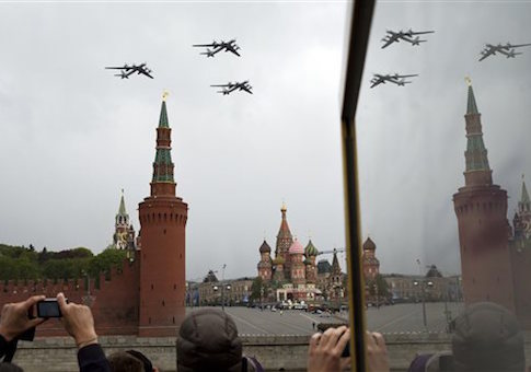 People watch as Russia's Air Force strategic bombers, Tu-95, fly over Red Square during a rehearsal for the Victory Day military parade