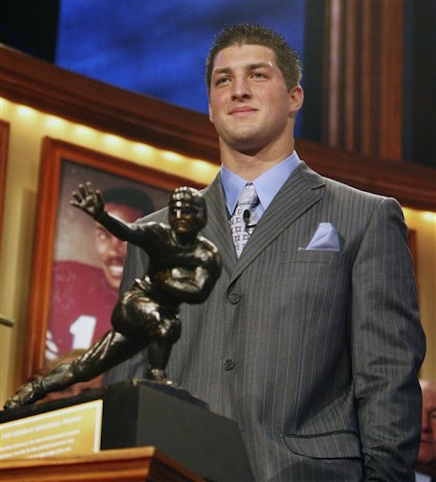 Florida quarterback Tim Tebow stands behind the Heisman Trophy after winning the award Saturday, Dec. 8, 2007 in New York. (AP Photo/Kelly Kline, Pool)