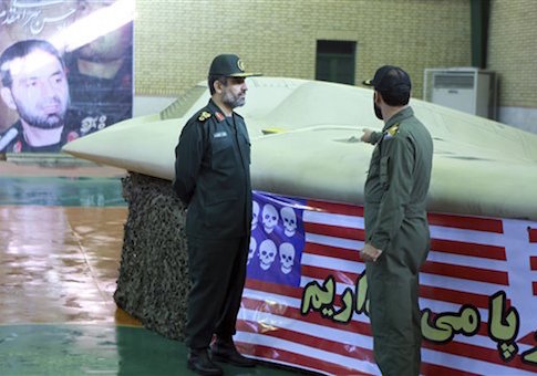 The chief of the aerospace division of Iran's Revolutionary Guards, Gen. Amir Ali Hajizadeh, left, listens to an unidentified colonel as he points to US RQ-170 Sentinel drone