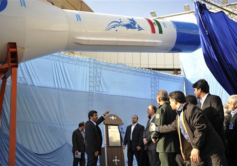 Former Iranian president Mahmoud Ahmadinejad gestures towards a model of Iran's new domestically-built light booster rocket Simorgh