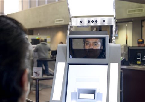 A man has his facial features and eyes scanned at a biometric kiosk