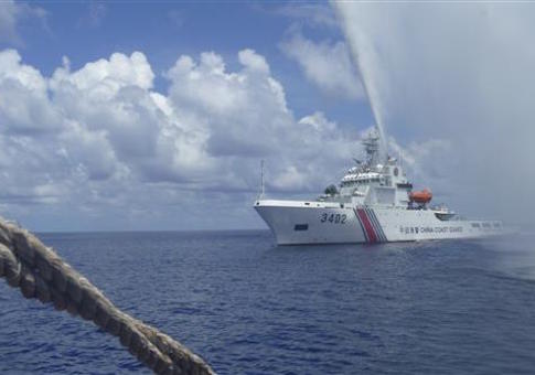 Chinese Coast Guard members approach Filipino fishermen off Scarborough Shoal / AP