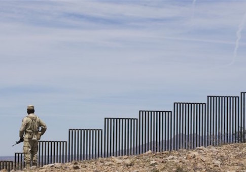 A Mexican soldier patrols along the U.S.-Mexico border wall on the outskirts of Nogales, Mexico