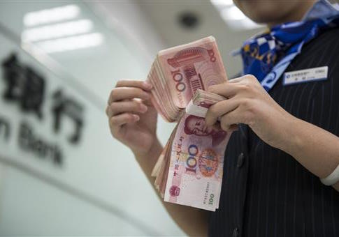 A Chinese clerk counts RMB (renminbi) yuan banknotes at a branch of China Construction Bank